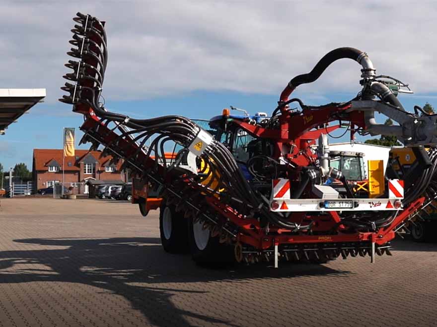 Traktor fährt über einen Hof