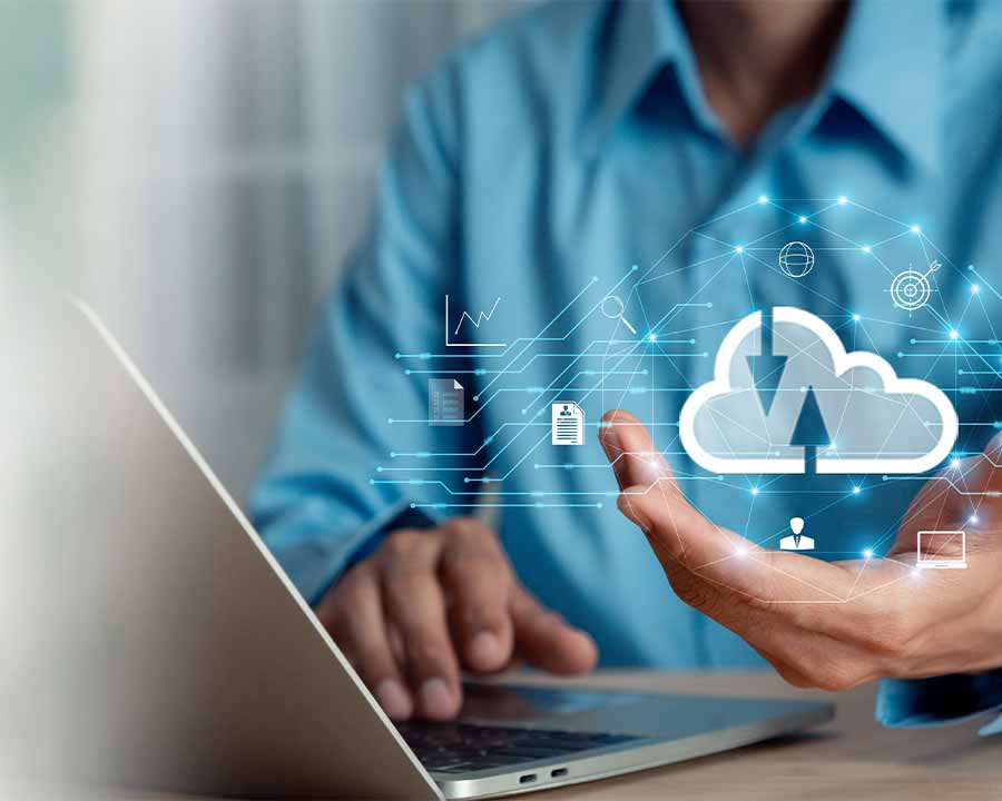 Man Hält IT Cloud in der Hand und bedient einen Laptop
