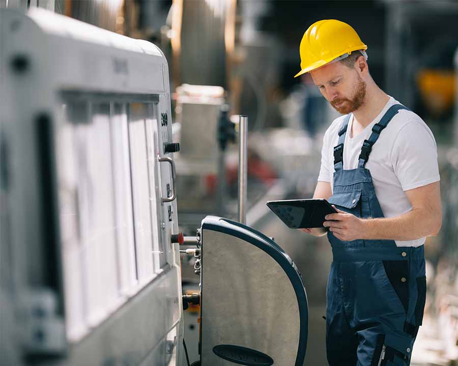 Mann steuert Industriemaschine mit Tablet