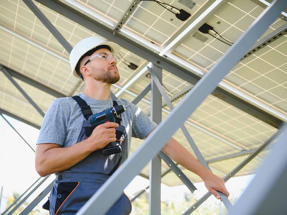 Handwerker steht unter einer Photovoltaikanlage