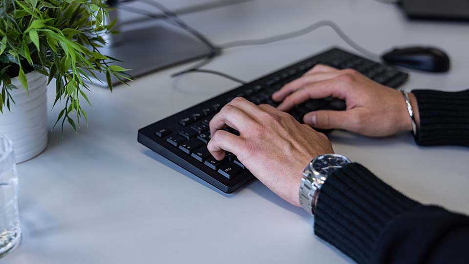 Hände tippen etwas auf einer Tastatur