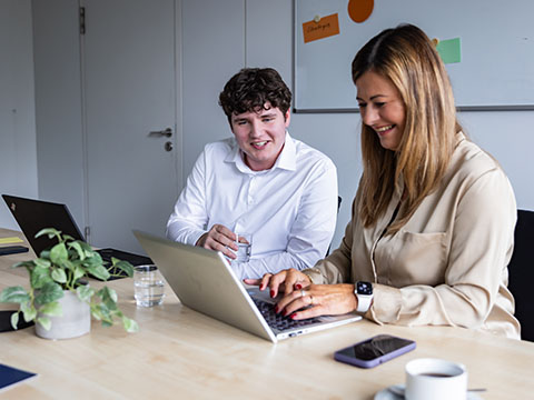 Ein Mann und eine Frau schauen auf ein Laptop