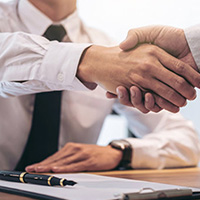 Zwei Menschen geben sich die Hand